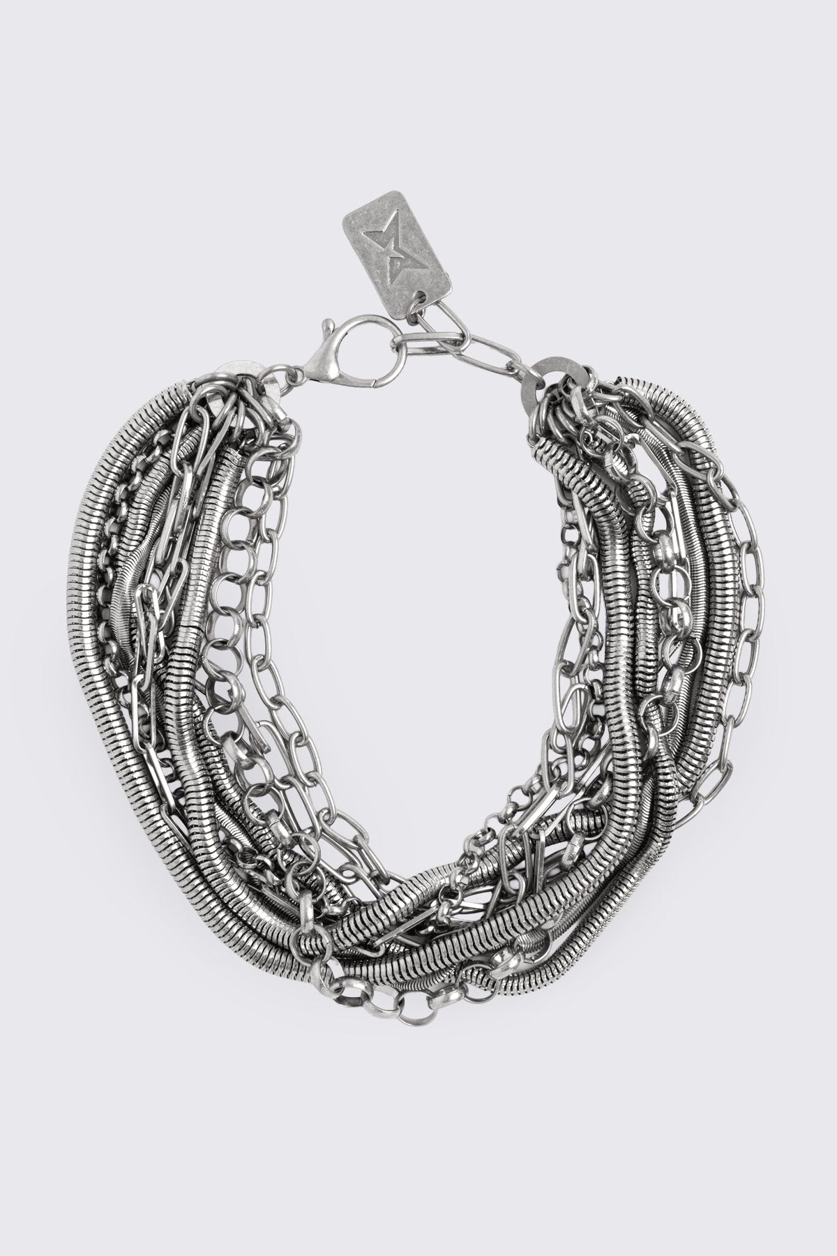 Chunky layered necklace in antique-silver metal with mixed chain textures, grunge aesthetic.