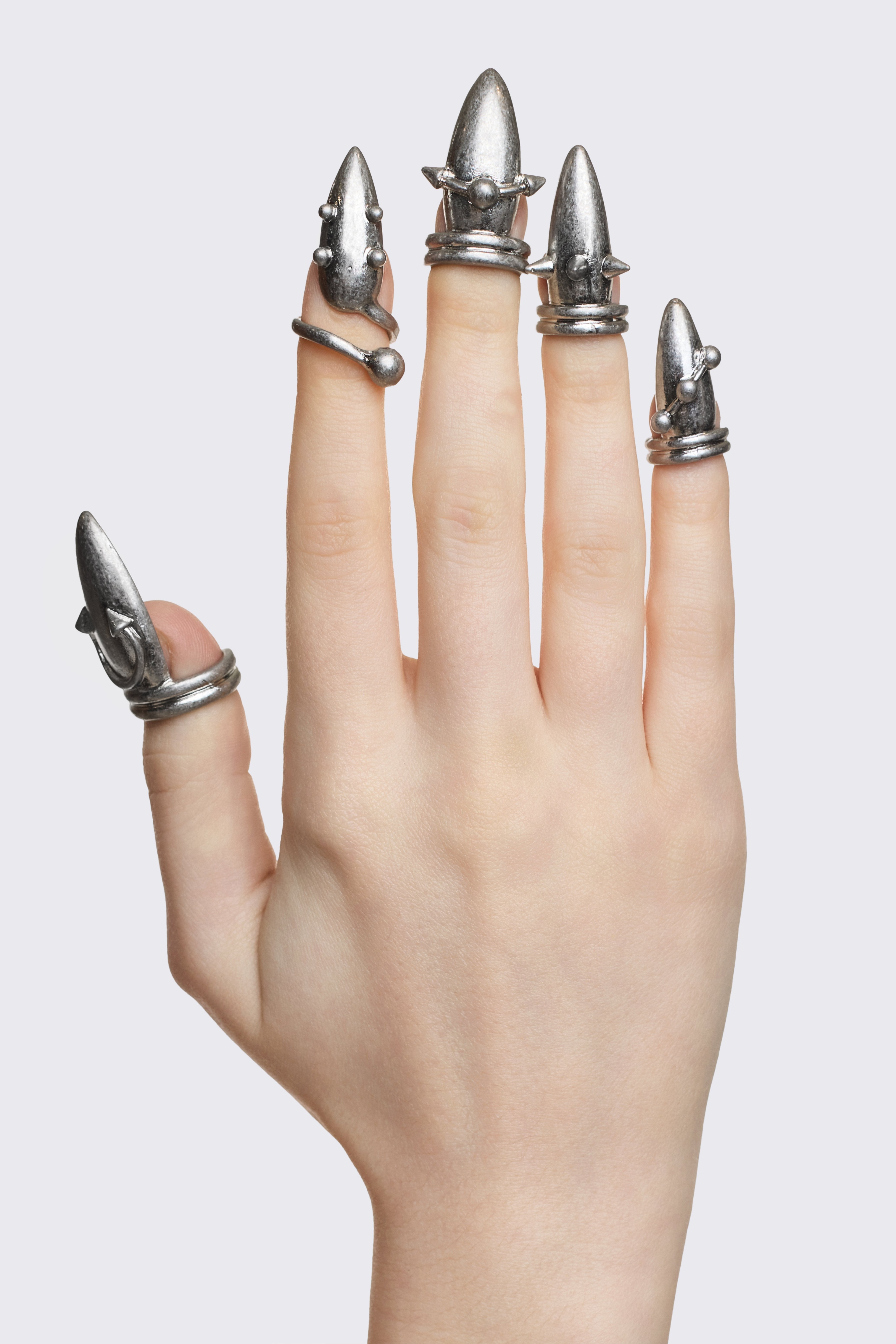 Oxidized silver zinc nail ring set with spike and piercing details, adjustable fingertip fit in a goth style.