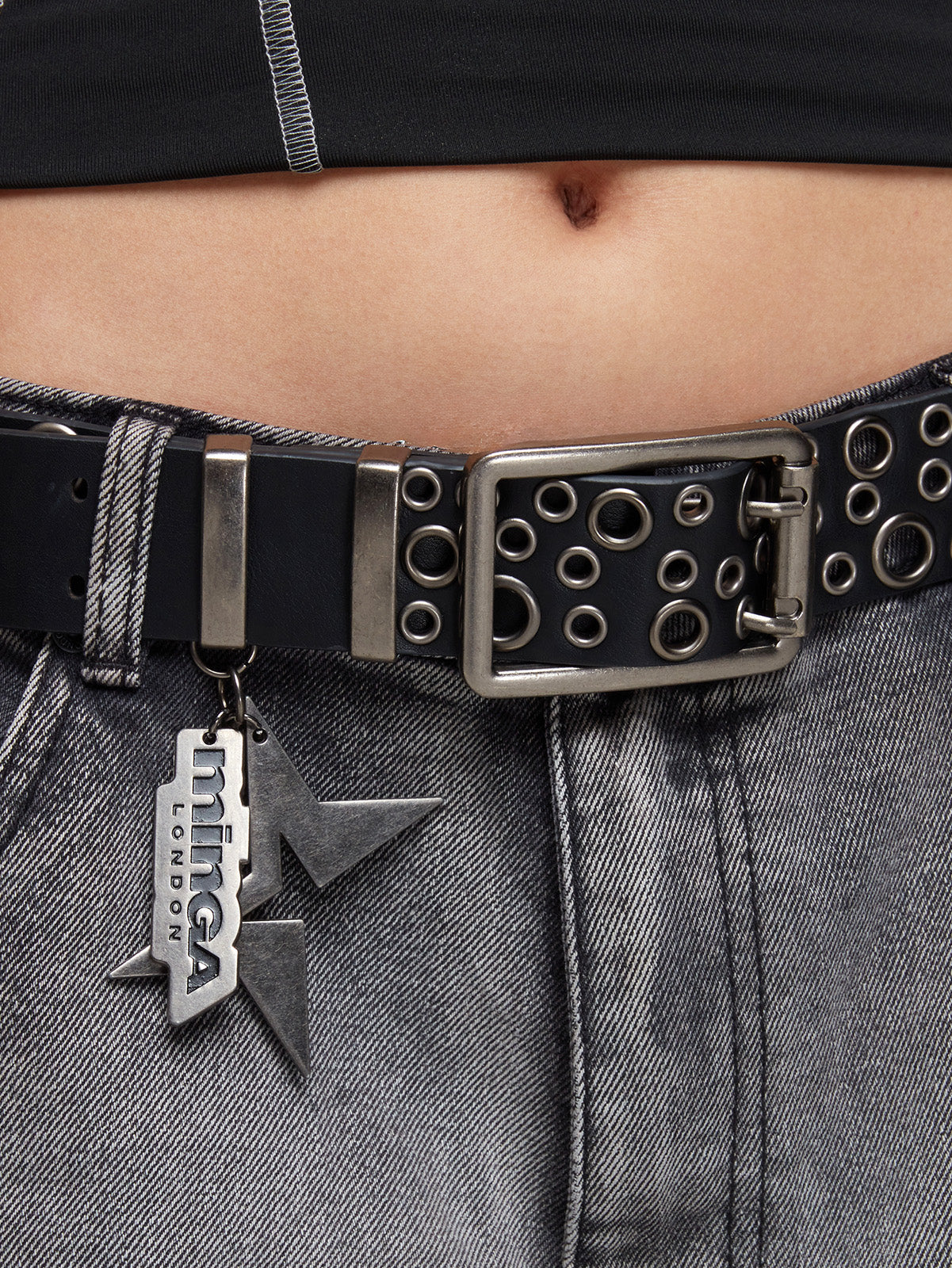 Double grommet leather belt in black with eyelets and minga logo pendant