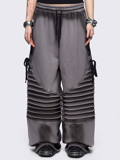 Grey washed wide leg sweatpants featuring moto pintuck panels, lace-up details and black fade out.