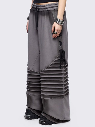 Grey washed wide leg sweatpants featuring moto pintuck panels, lace-up details and black fade out.