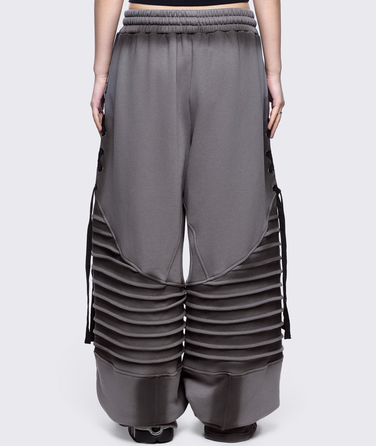 Grey washed wide leg sweatpants featuring moto pintuck panels, lace-up details and black fade out.
