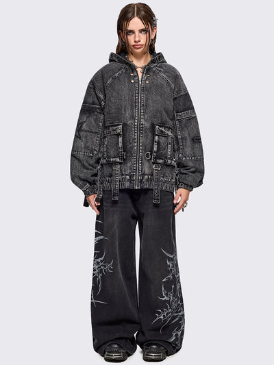 Black acid washed denim bomber jacket featuring boxy oversized fit, front flap pockets, buckle straps, eyelets, metal hardware and seams details.