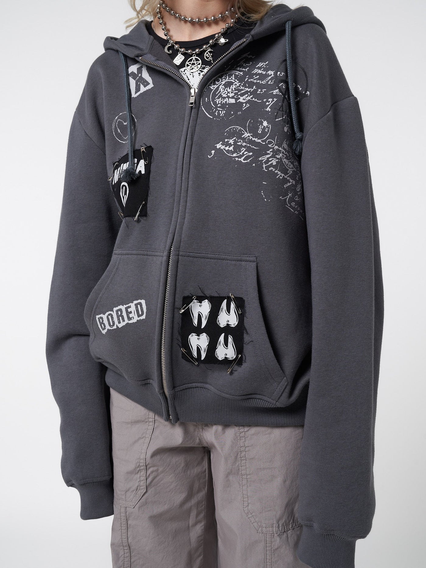 Zip up hoodie jacket in grey with front prints, patches and safety pins