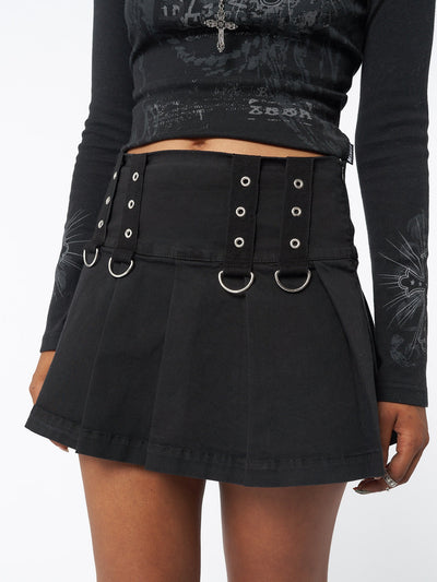 Pleated mini skirt in black with grommet eyelet strip and D-ring details