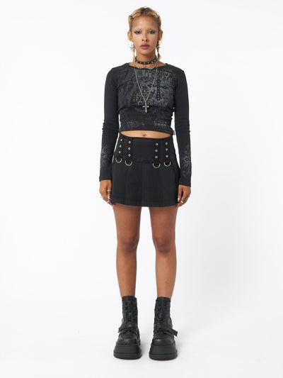 Pleated mini skirt in black with grommet eyelet strip and D-ring details